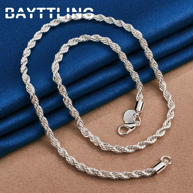 Silver rope chain necklace on blue and brown fabric background