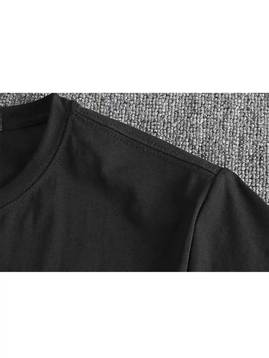 Detail of the shoulder seam on a black cotton t-shirt