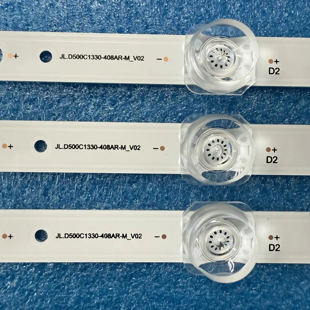 Close-up of three LED backlight strips showing serial number markings and lens detail.