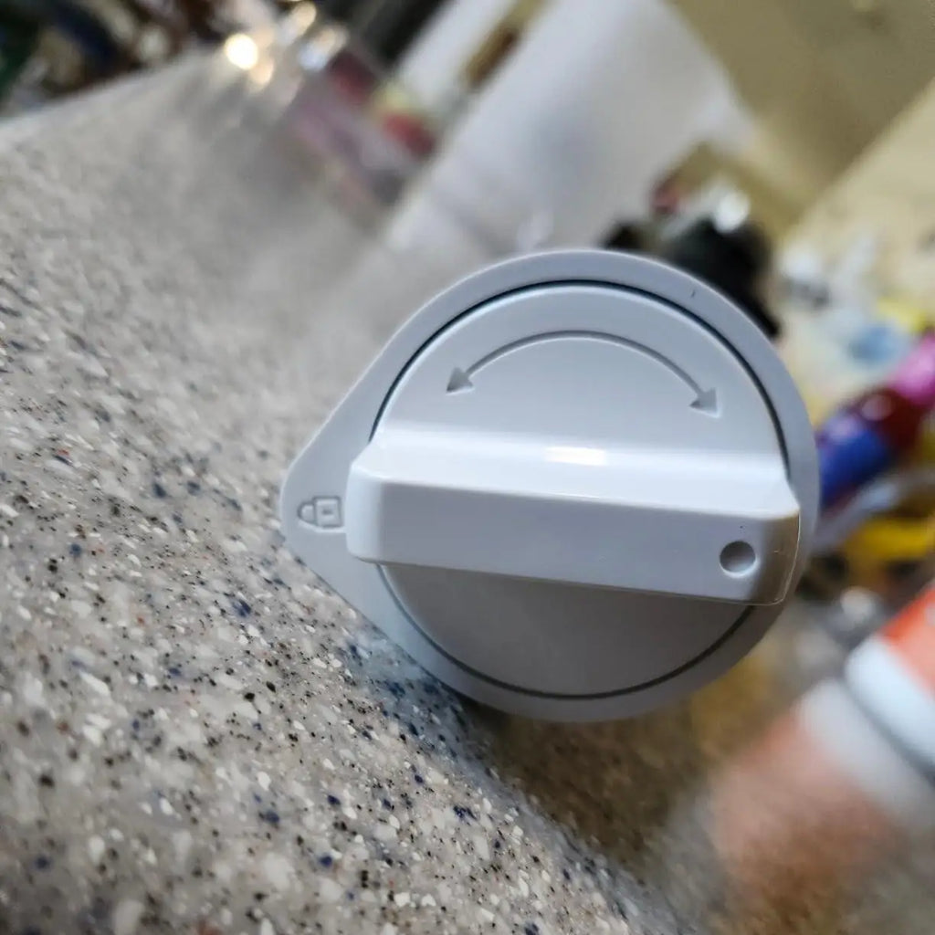 Top view of the white plastic connection head of a refrigerator water filter