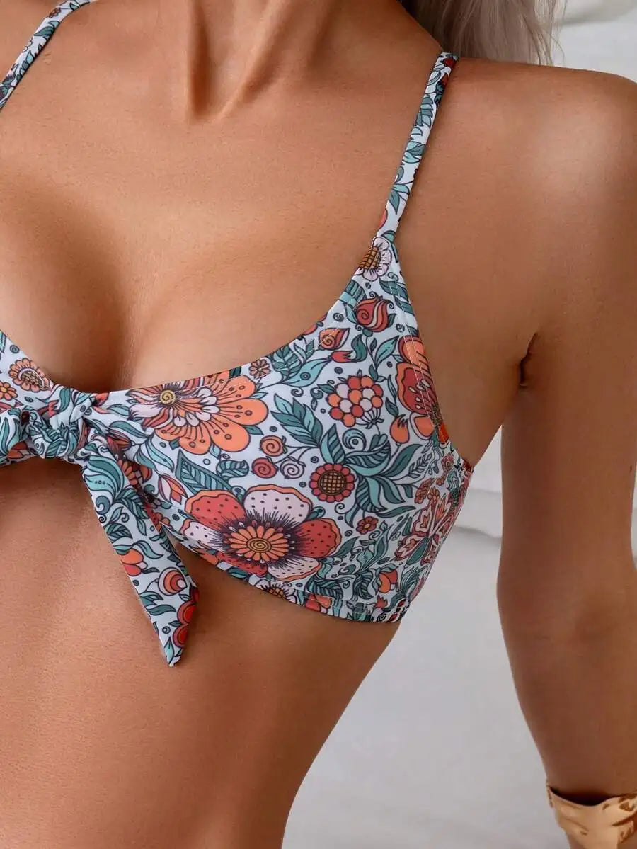 Close up of a floral print bikini top with spaghetti straps and a bow tie front