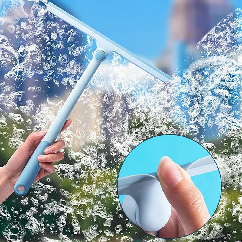 Handheld squeegee cleaning soap bubbles from a glass window
