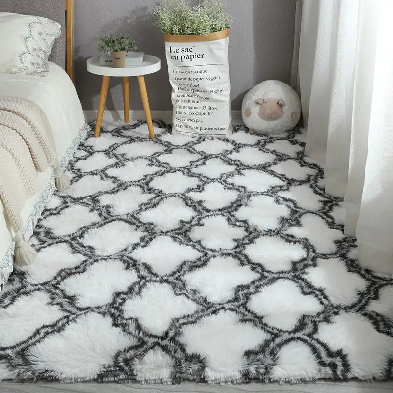 White plush area rug with black geometric lattice pattern in a bedroom.