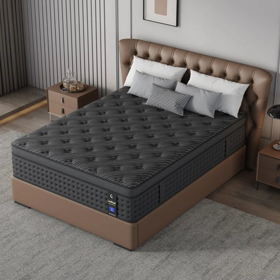 A charcoal-grey hybrid mattress placed on a bed frame in a contemporary bedroom.