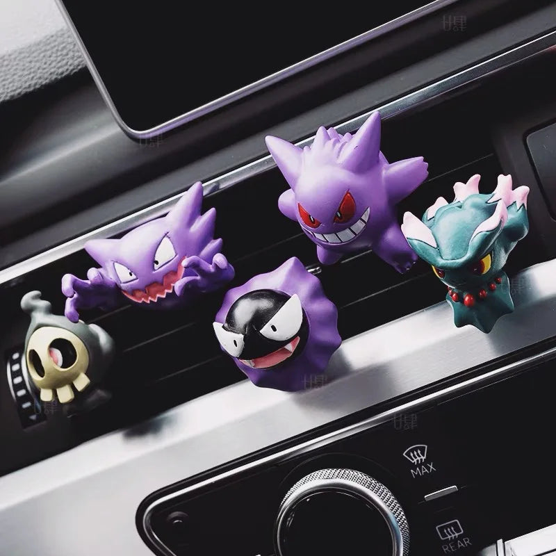 A collection of ghost type monster figures designed as car air vent clips on a dashboard