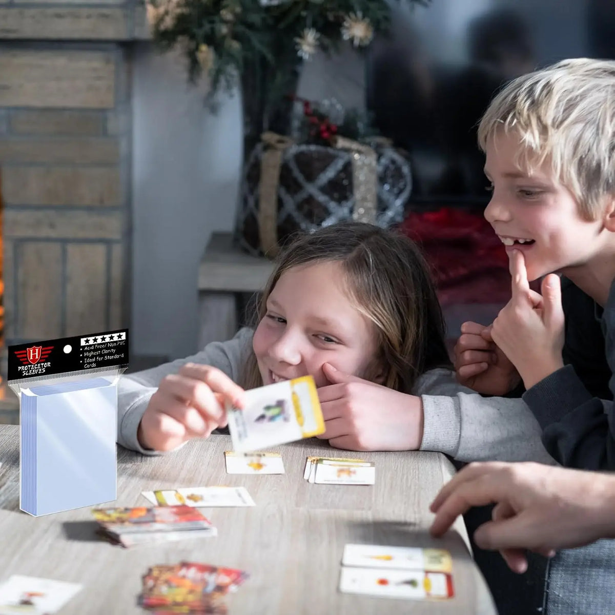 Children playing with trading cards at a table with a pack of card sleeves visible in the foreground.