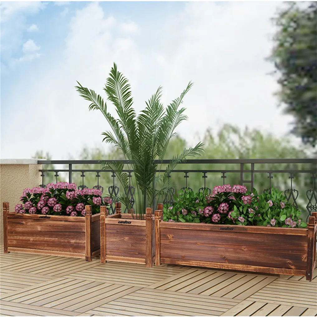 Three wooden garden planters of varying sizes placed on a wooden patio deck