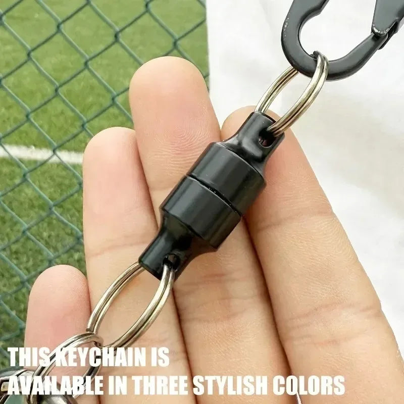 A close-up of a black magnetic keychain connector held in a hand.
