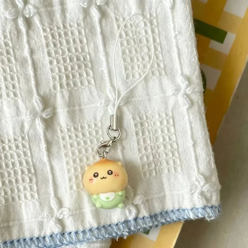 A single resin character charm with a lanyard resting on a white patterned fabric.