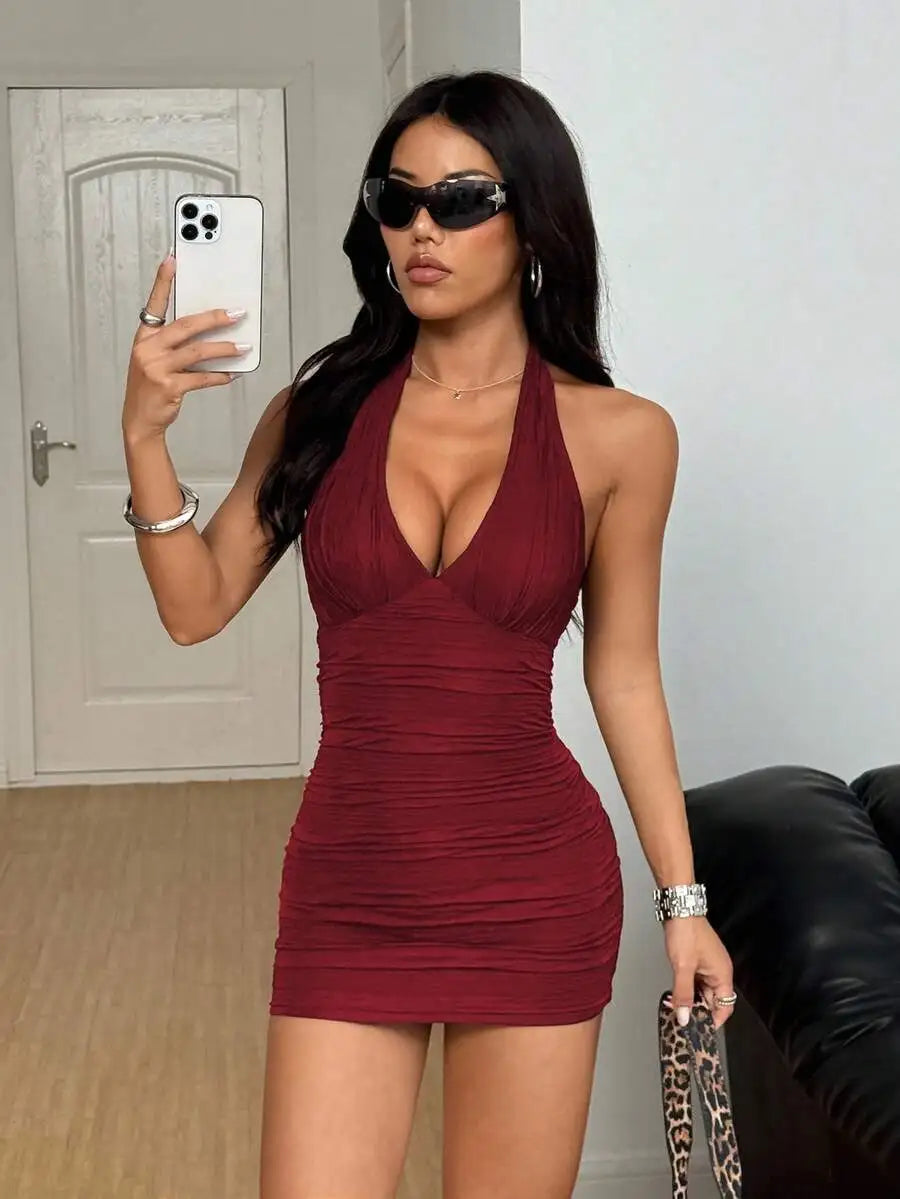 Burgundy sleeveless halter mini dress with ruched textured fabric, model wearing sunglasses
