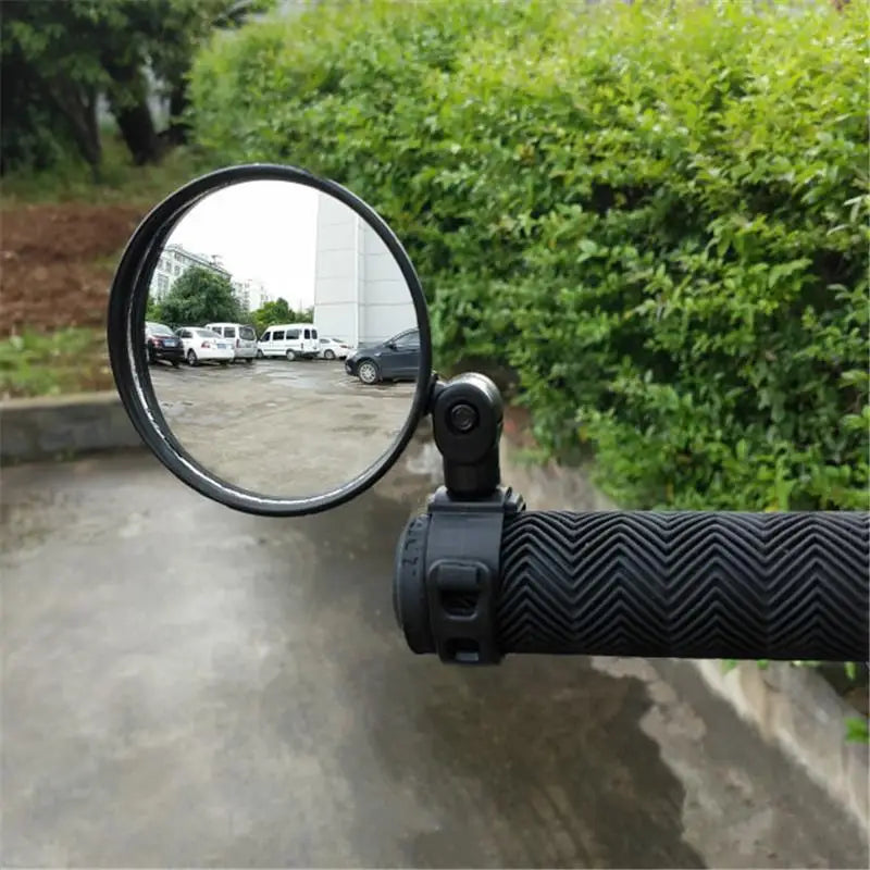 Round bicycle or electric scooter handlebar mirror attached to a handle grip