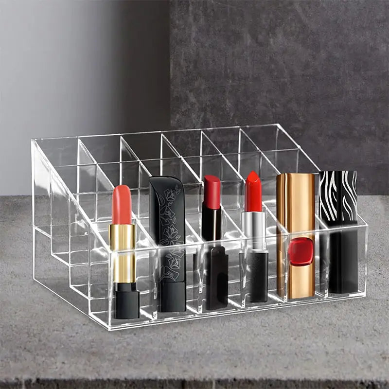 A clear acrylic lipstick display rack holding several different lipstick tubes of various colors and designs