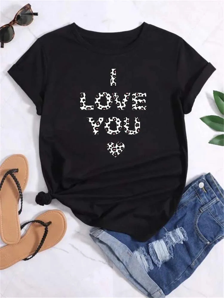 Black short sleeve t-shirt with leopard print text and heart graphic, paired with denim shorts and sandals