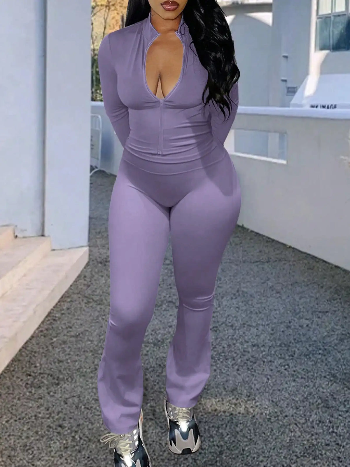 A woman wearing a purple long-sleeve zip-up top and matching flared trousers.