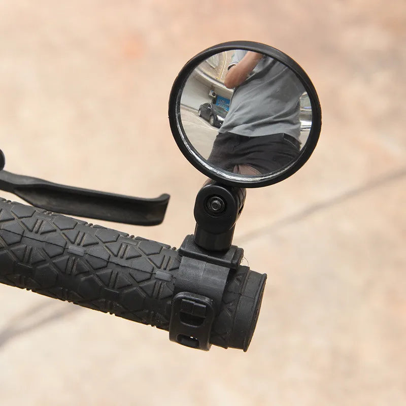 Round handlebar mirror on a scooter or bike with a reflection of a person