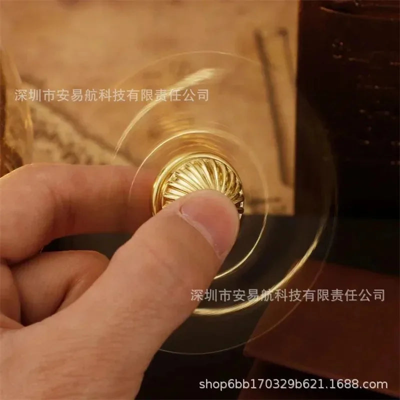 A golden snitch fidget spinner spinning in a person's hand