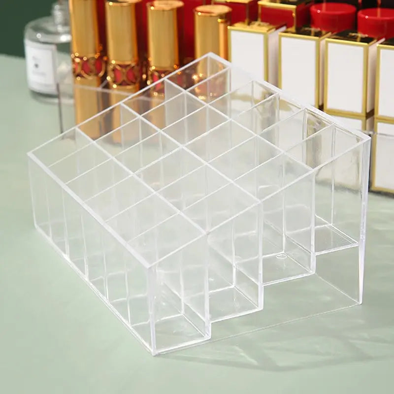 An empty clear acrylic lipstick organizer with 24 individual slots for cosmetic storage