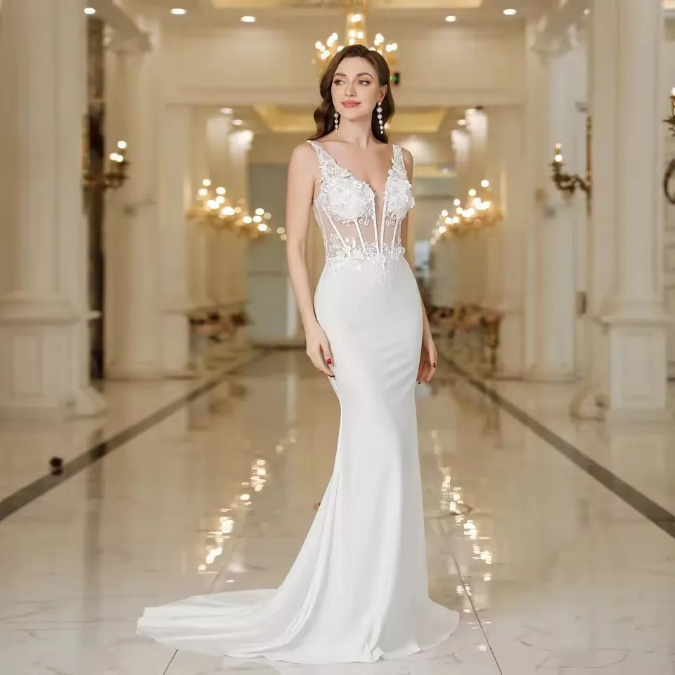 White floor-length mermaid wedding dress with lace bodice, V-neck, and thin straps
