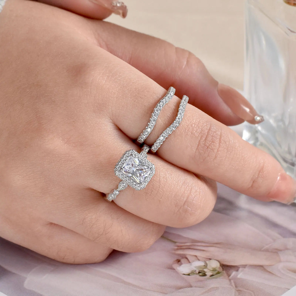 Hand wearing detached sterling silver pave bands and rectangular engagement ring