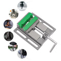 4-inch drill press vise with green non-slip jaws and cast iron construction, shown with various machining tools
