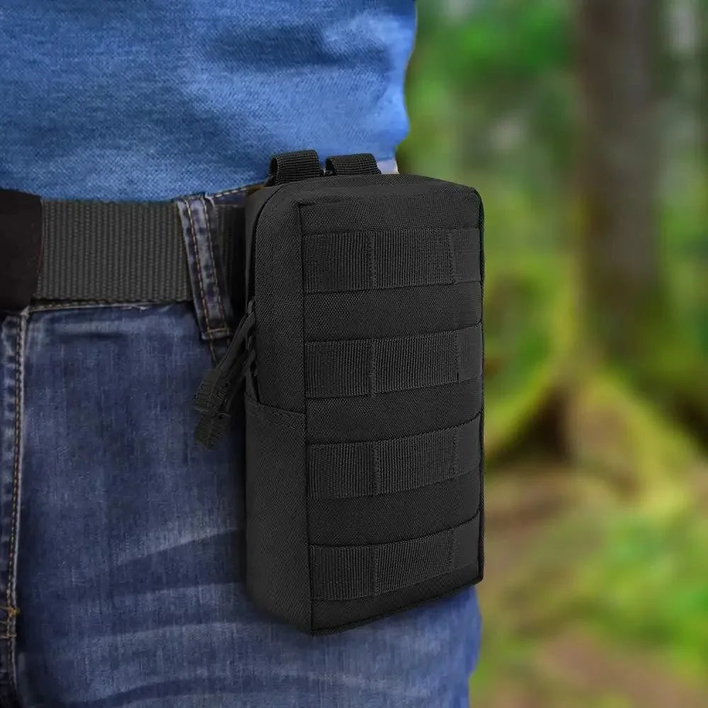 A person wearing a black rectangular tactical molle pouch on their belt.