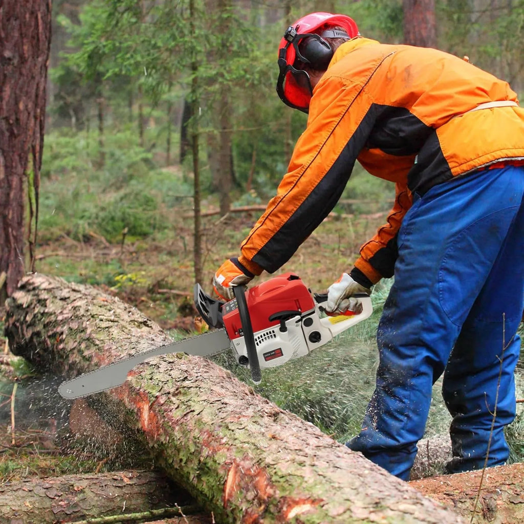 Lumberjack in safety gear using a petrol chainsaw to cut a log