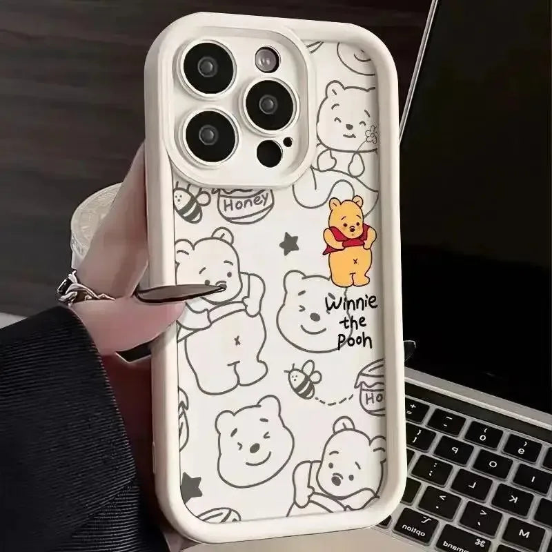 White phone case with line art cartoon character illustrations held in a hand