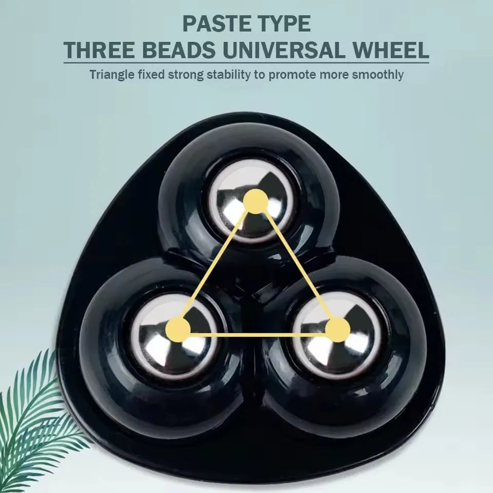 A black triangular universal wheel showing its three stainless steel ball bearings arranged in a triangle.