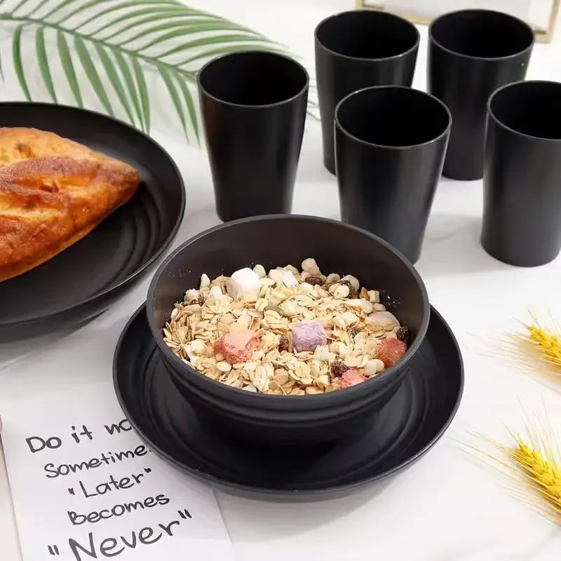 A black wheat straw bowl filled with cereal, with a cup and a plate with bread on a table.