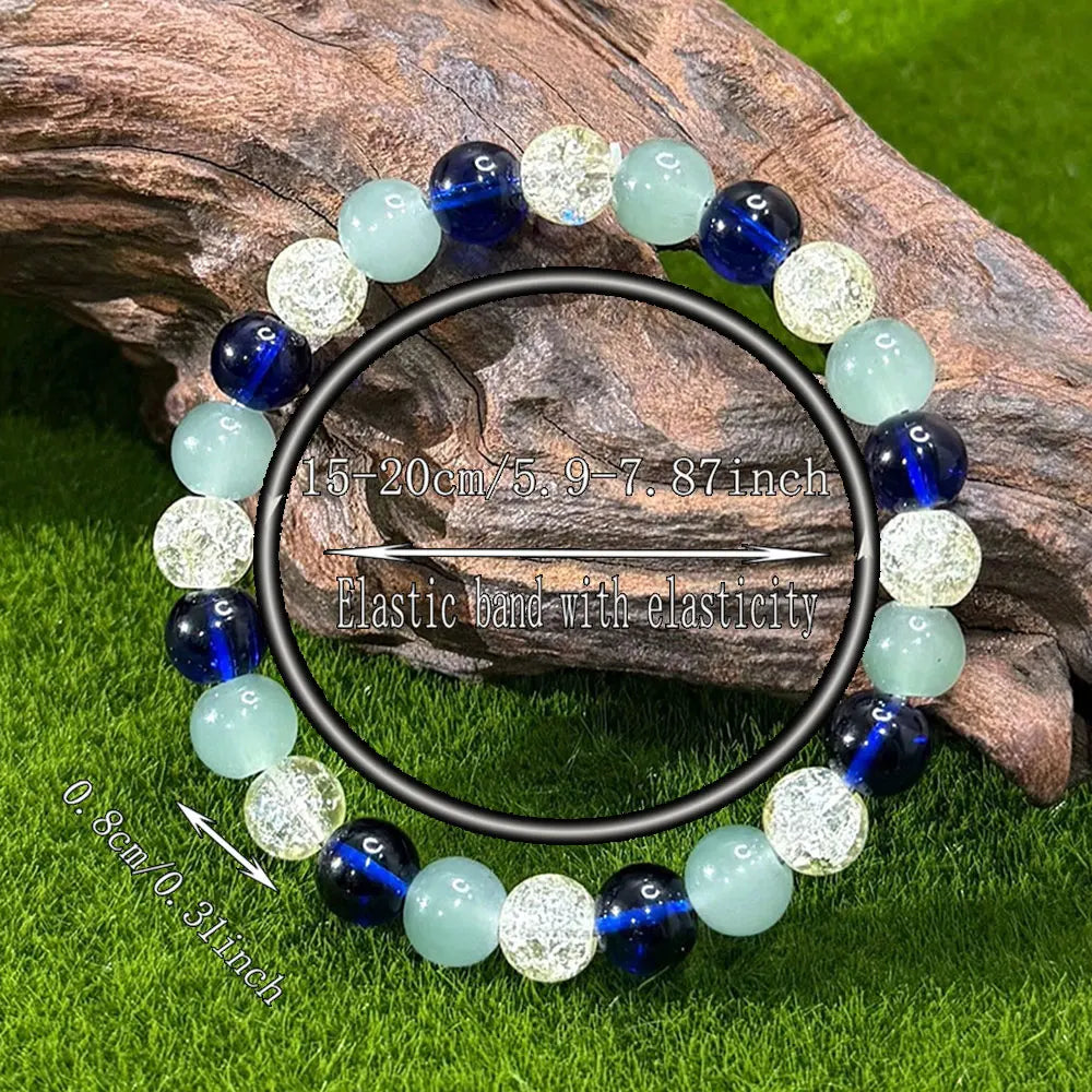 Beaded elastic bracelet with blue, light green and crackled clear beads featuring size measurements overlaid
