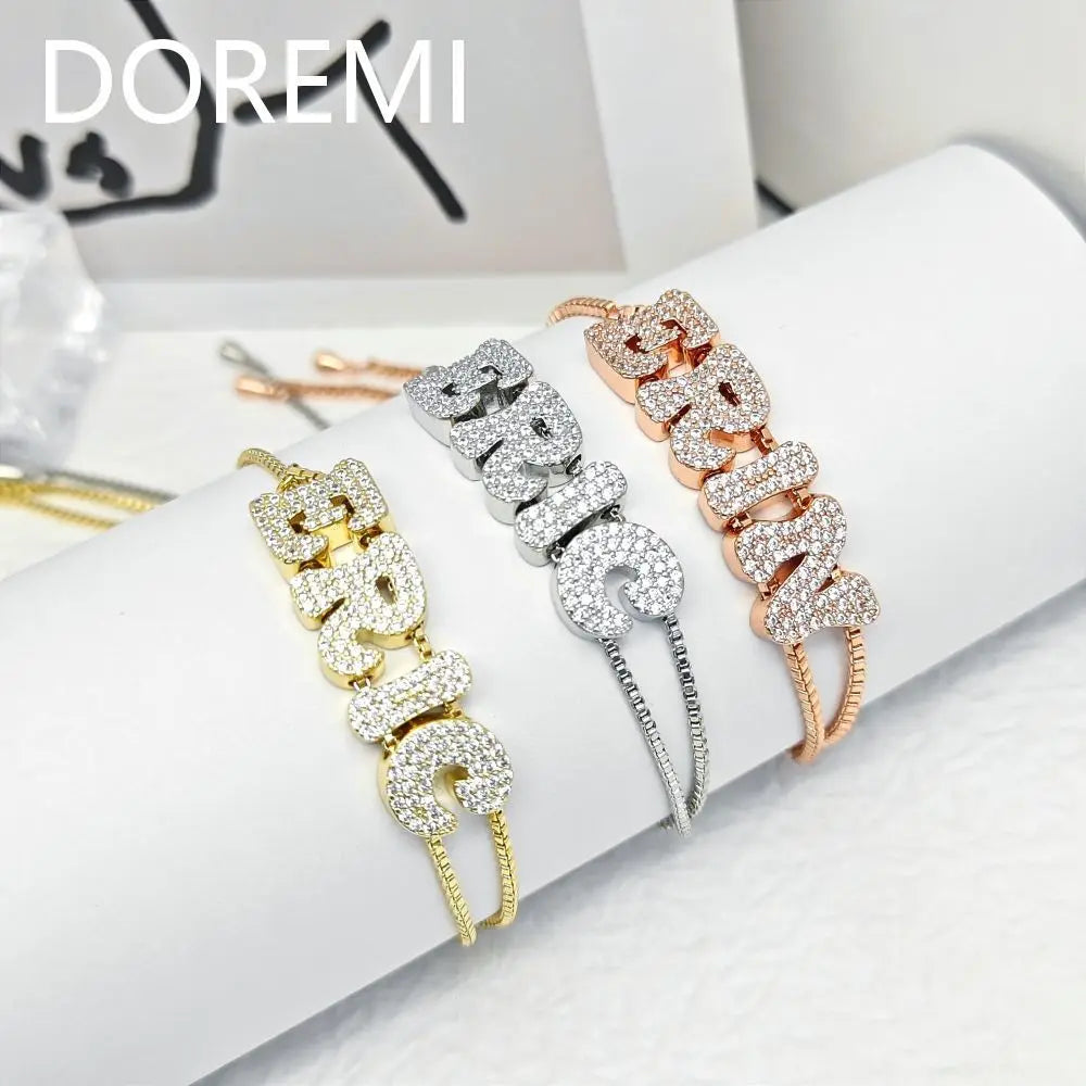 Set of three custom alphabet letter slider bracelets in silver, gold, and rose gold tones.