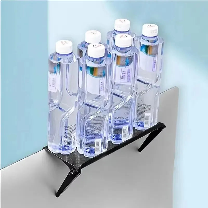 Black adjustable screen top shelf mounted on a monitor supporting several full water bottles to demonstrate weight capacity