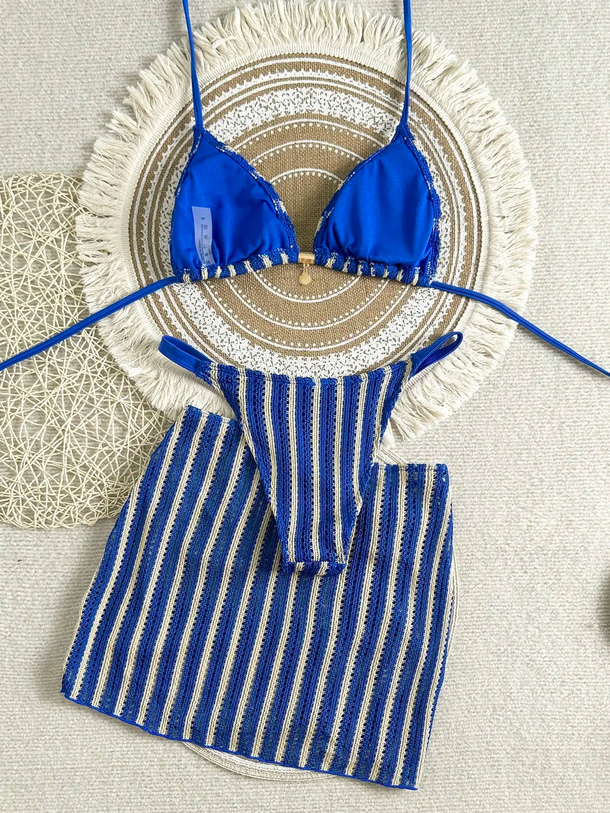 Back view flat lay of blue and beige striped knit bikini set and matching skirt