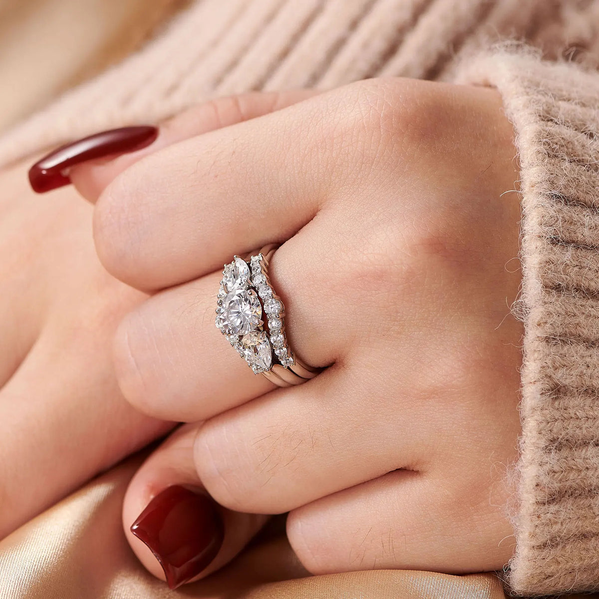 Side profile of a hand wearing a three-piece sterling silver simulated diamond wedding ring set