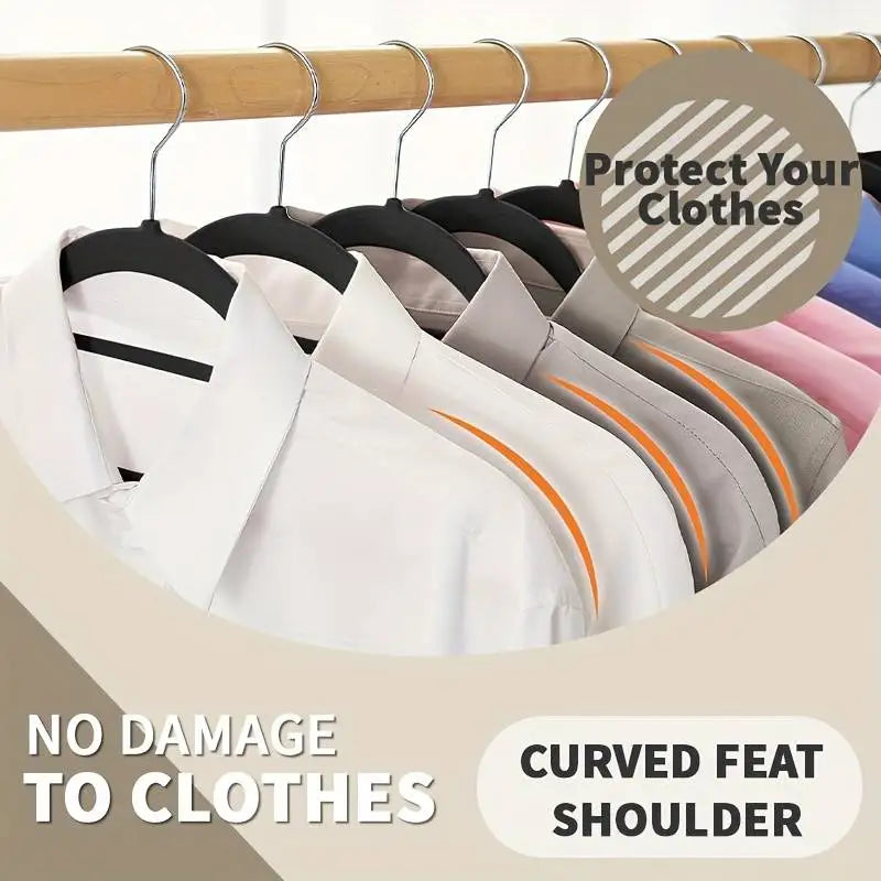 Close up of clothes on black velvet hangers highlighting the curved shoulder design.