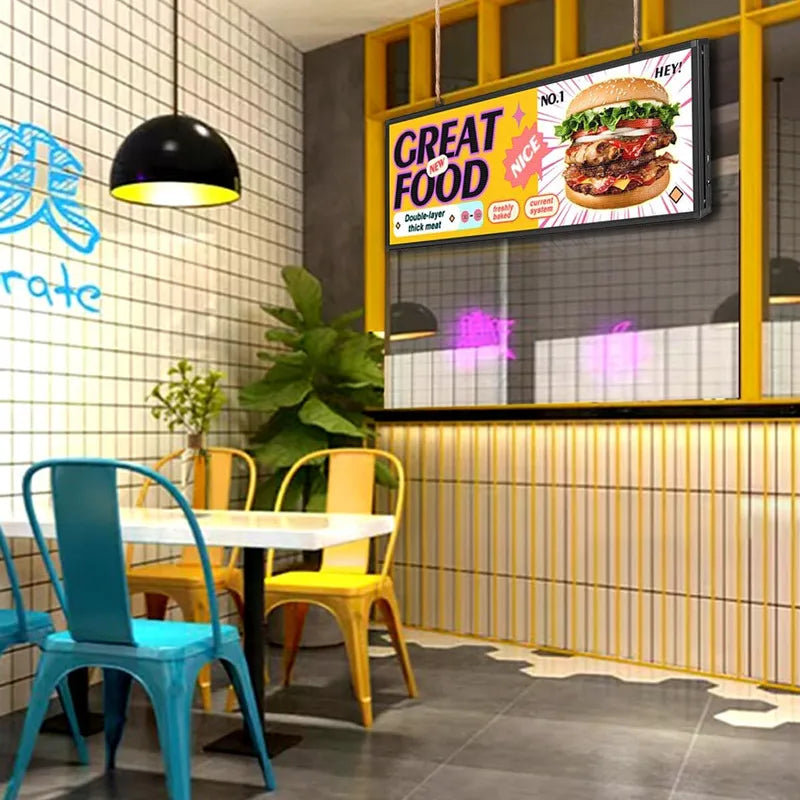 LED sign board suspended above a restaurant dining area showing a burger advertisement.