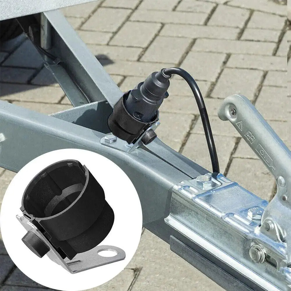 Black trailer plug holder mounted on a trailer frame with a cable inserted