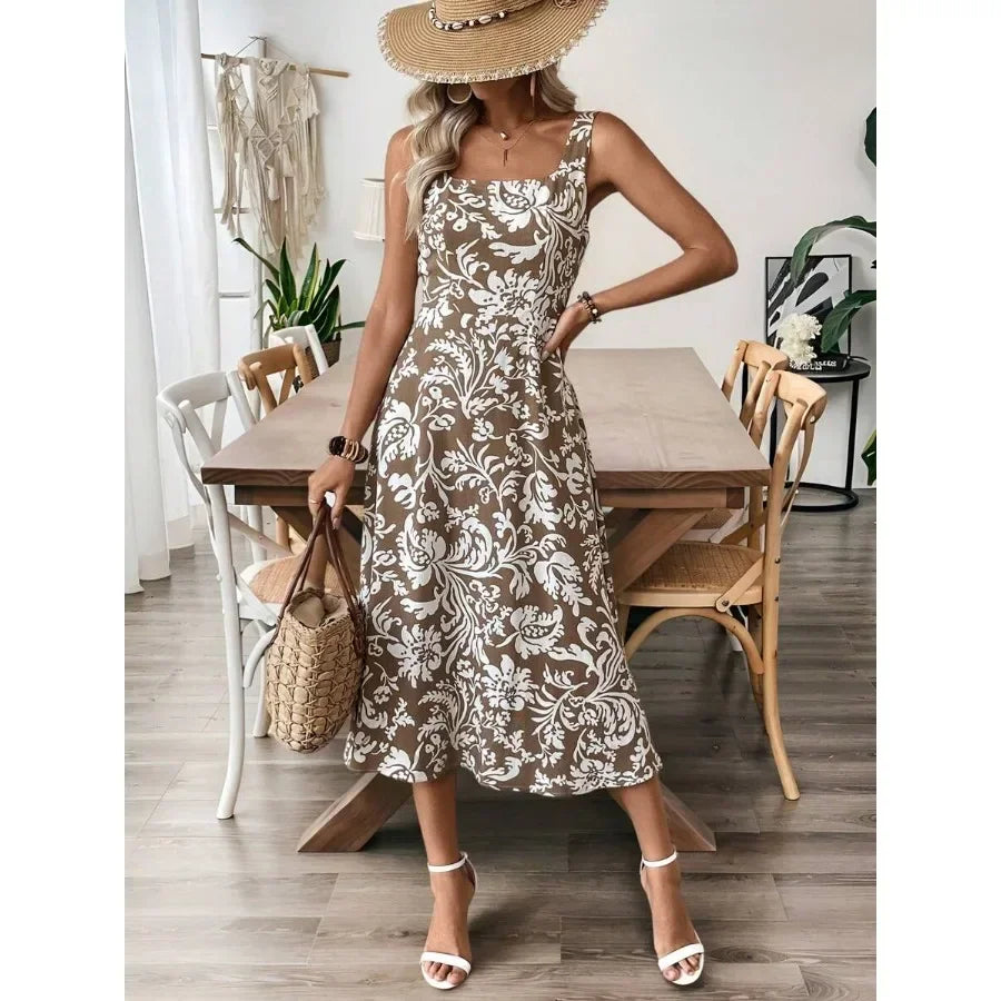 Women's brown floral print midi dress worn with a sun hat, white sandals, and a straw tote bag.
