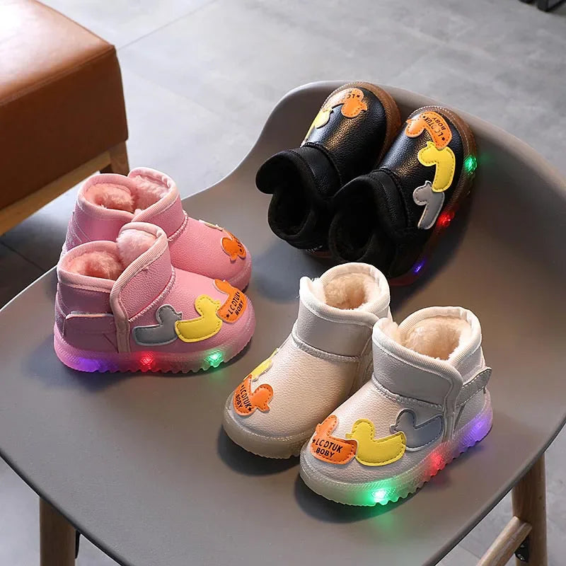 Three pairs of toddler winter boots in pink, white, and black with duck appliques and light-up soles