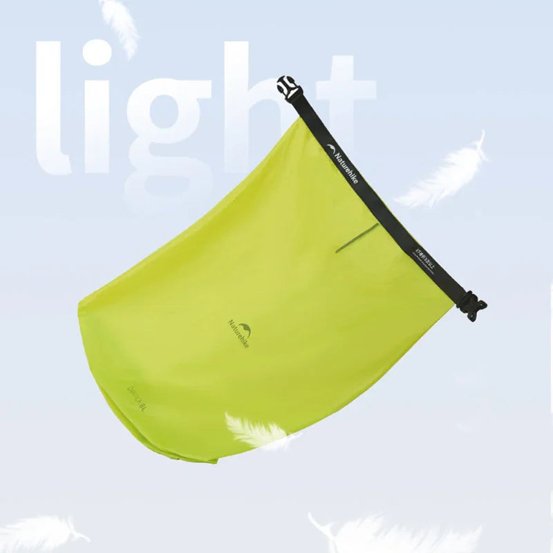 Green waterproof compression dry bag floating against a light blue background
