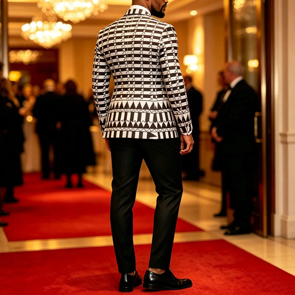 A man from behind wearing a black and white geometric print blazer with black trousers.