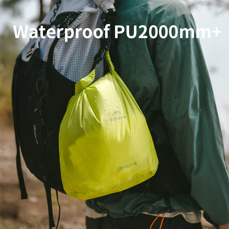Green waterproof compression dry bag attached to an outdoor backpack