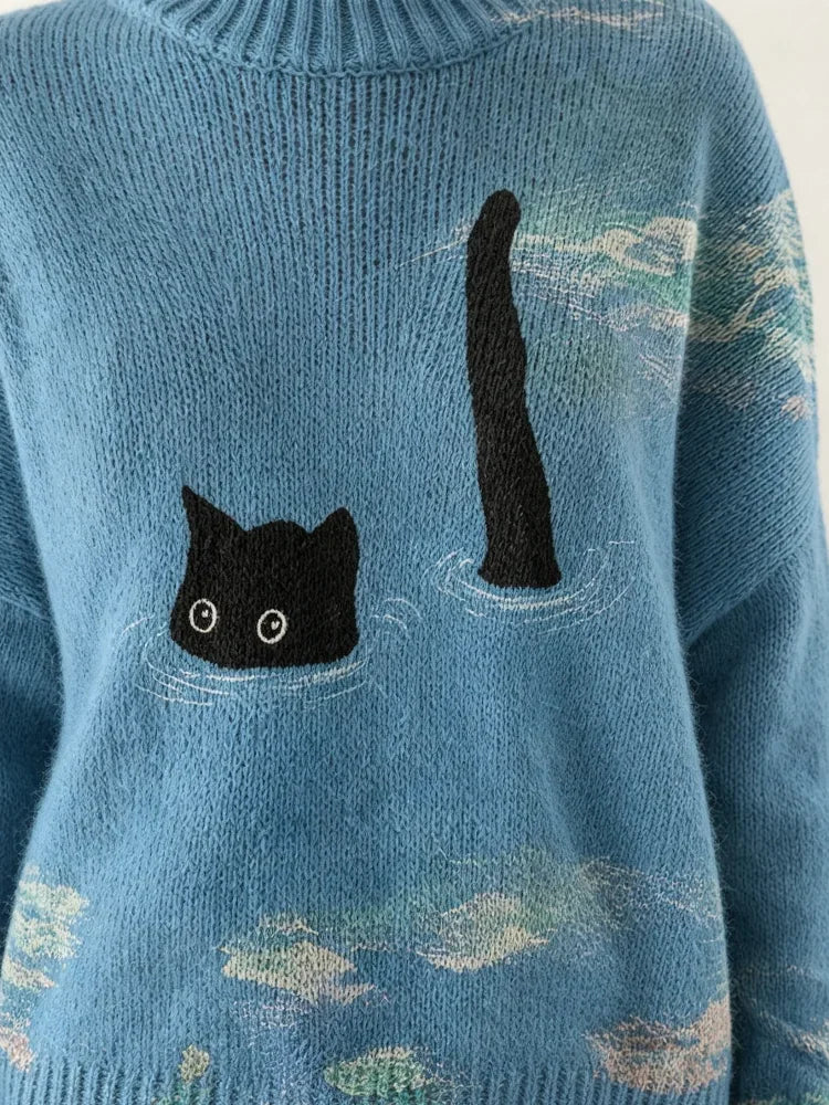 Close-up of a blue knitted sweater with a black cat design swimming in the ocean