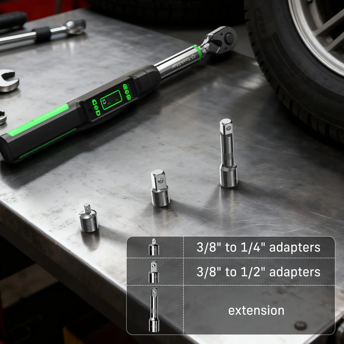 Digital torque wrench with included socket adapters and extension piece on a workbench