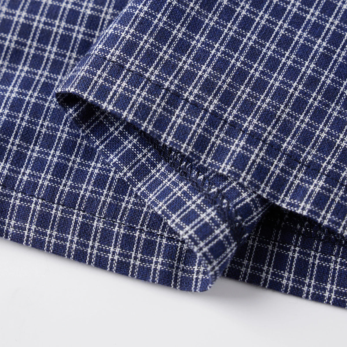Hem and stitching detail of blue plaid shirt