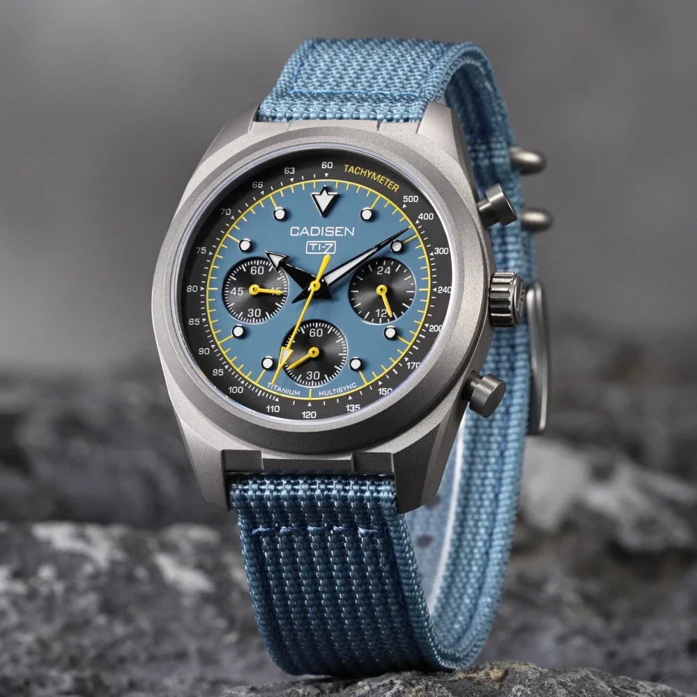 Blue dial chronograph watch with light blue canvas strap on stone surface
