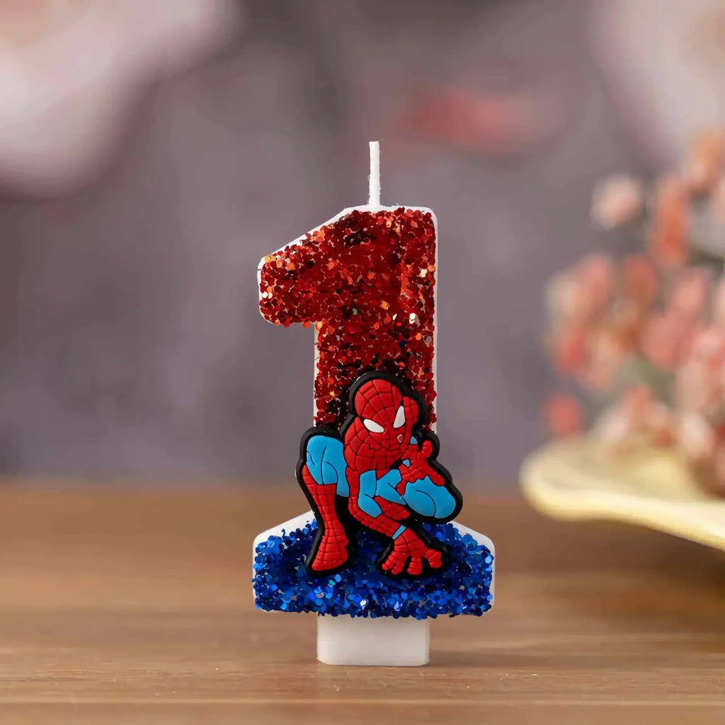 Number 1 birthday candle decorated with red and blue glitter and a cartoon superhero figure