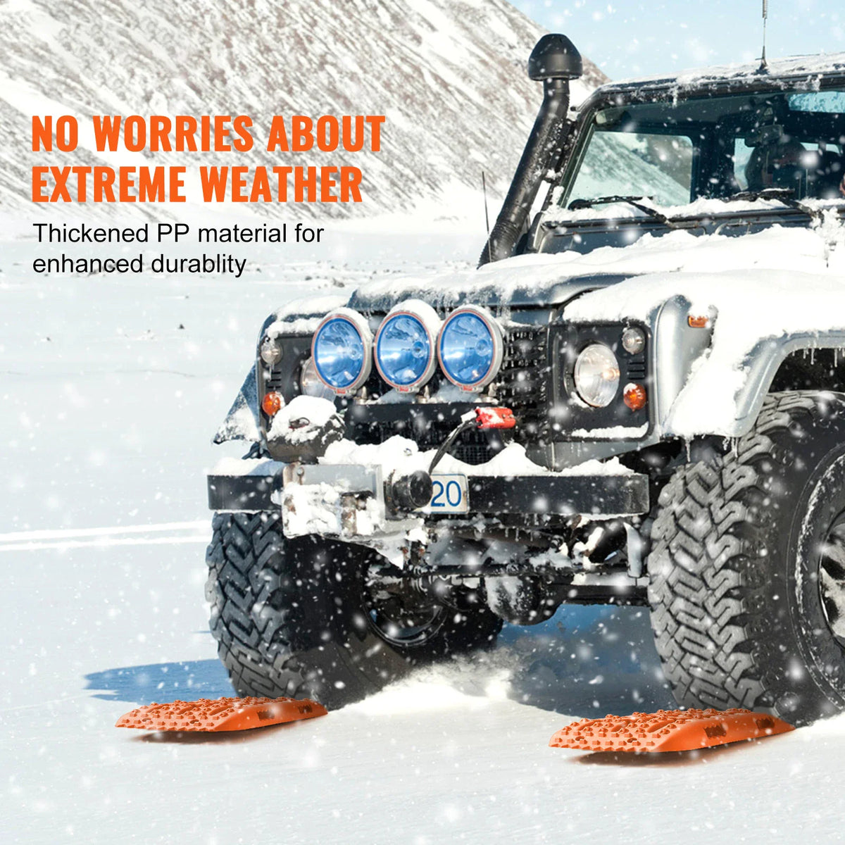 Orange recovery traction boards placed under the wheels of a vehicle driving in deep snow.