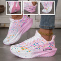 Pink and white paint splatter sneakers with a thick sole on feet