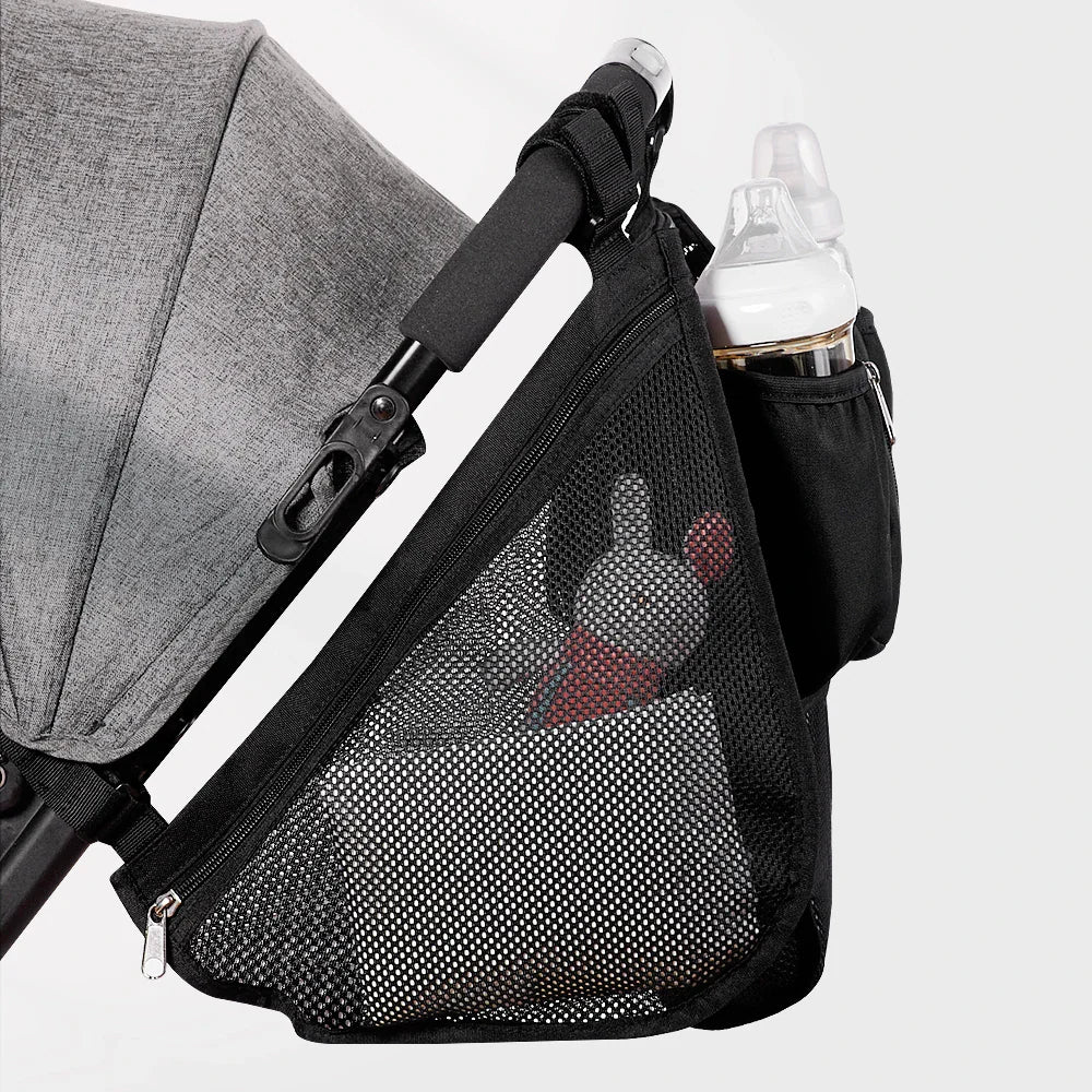 Side profile of a black stroller organizer bag with mesh storage pocket and bottle compartment attached to a stroller